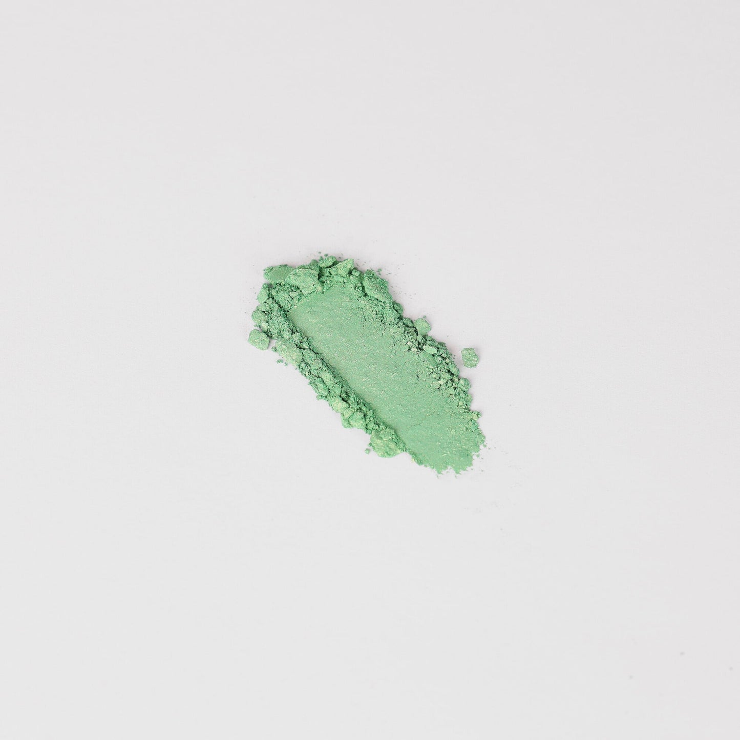 Glow Pressed Eyeshadow in vibrant green shade, showcasing rich vegan pigment and smooth texture for multi-use application.