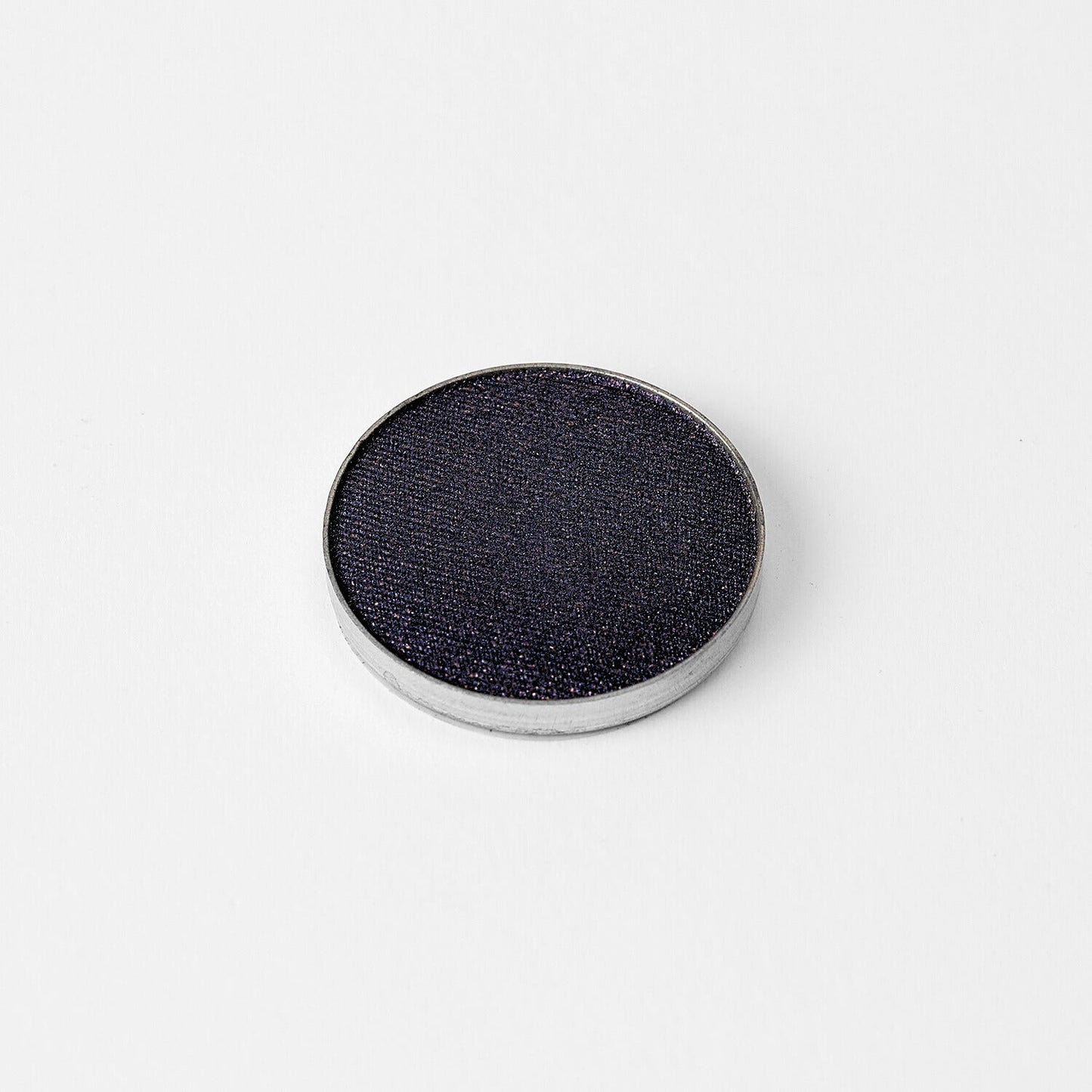Glow Pressed Eyeshadow in dark shade shown in metal pan, perfect for creating a bold, luminous eye look.