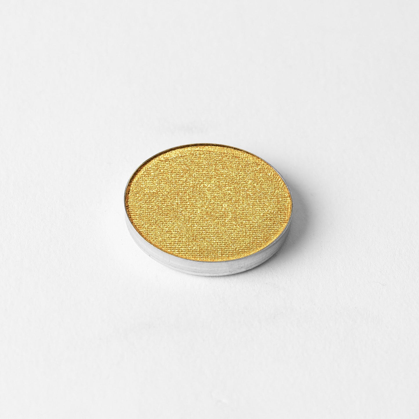 Glow Pressed Eyeshadow in vibrant yellow shade on white background, showcasing luminous vegan pigments for multi-use application.