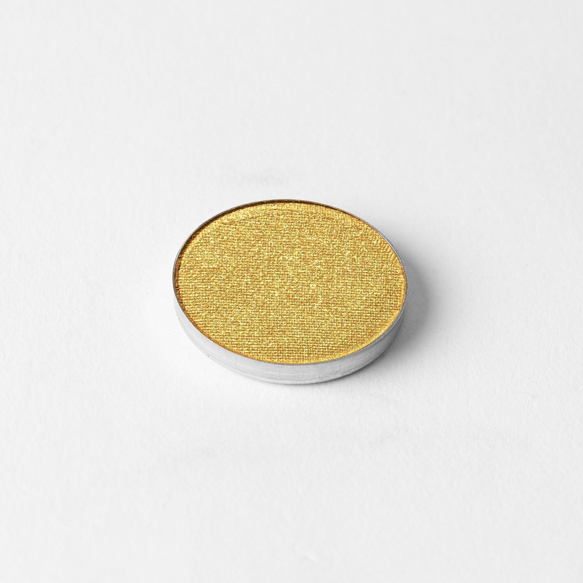 Glow Pressed Eyeshadow in vibrant yellow shade on white background, showcasing luminous vegan pigments for multi-use application.