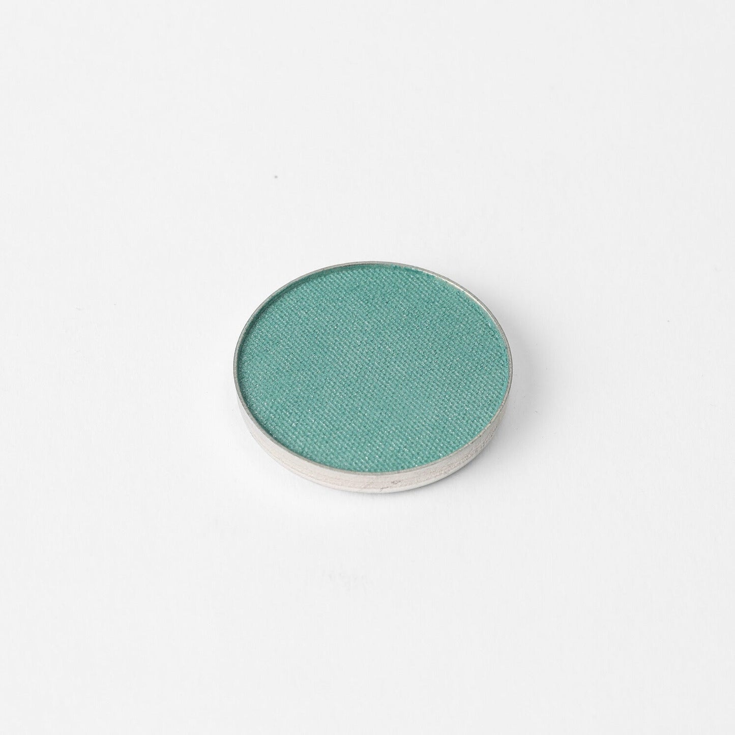 Glow Pressed Eyeshadow in a vibrant teal shade, perfect for adding a luminous touch to any eye makeup look.