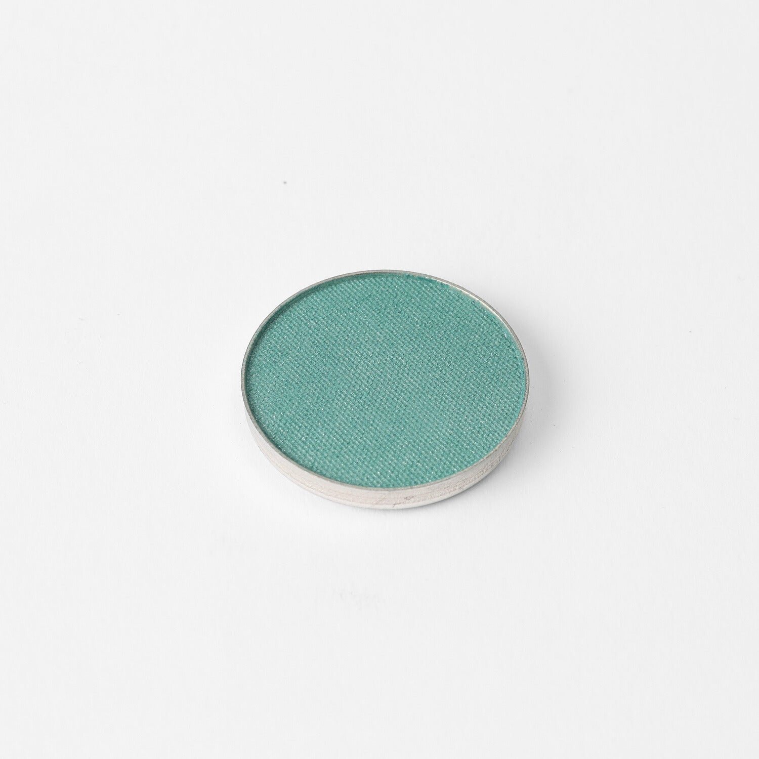 Glow Pressed Eyeshadow in a vibrant teal shade, perfect for adding a luminous touch to any eye makeup look.
