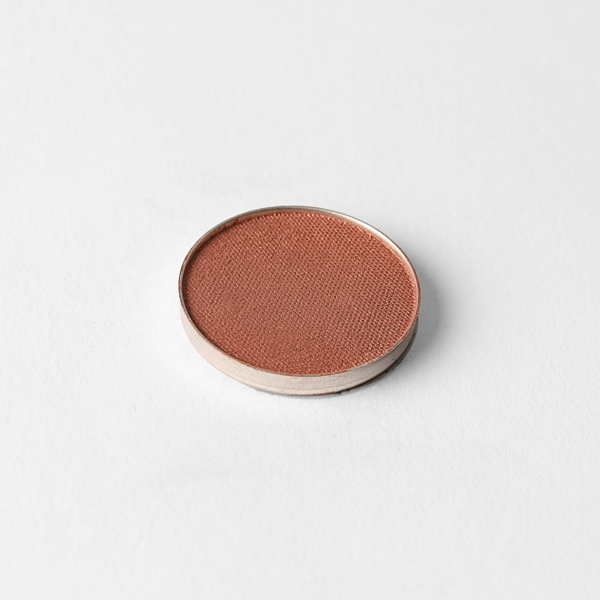 Glow Pressed Eyeshadow in a round pan, featuring rich vegan pigments for a luminous and buildable look, ideal for subtle to bold shimmer.