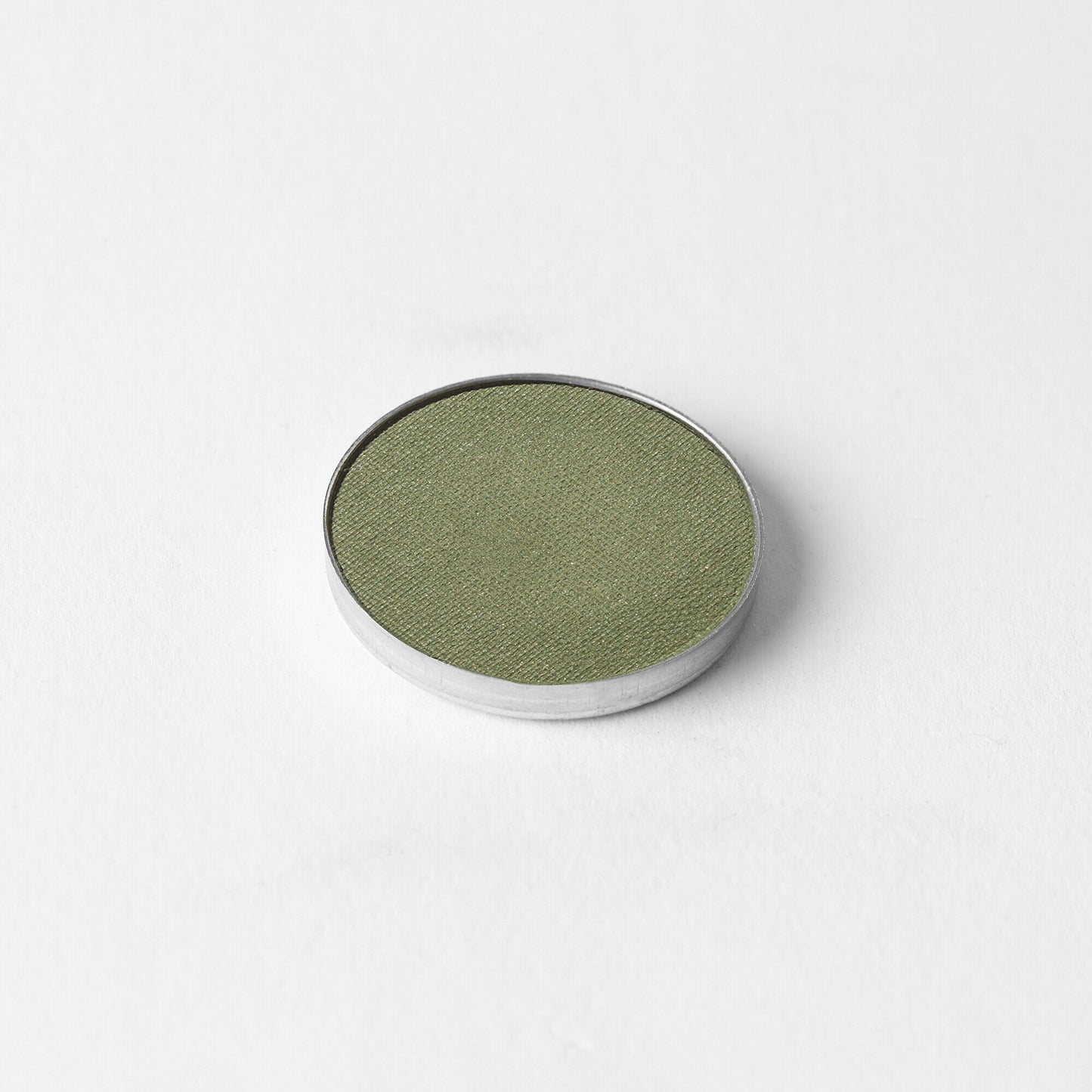 Olive green Glow Pressed Eyeshadow pan on white background, showcasing vegan pigments and smooth texture.