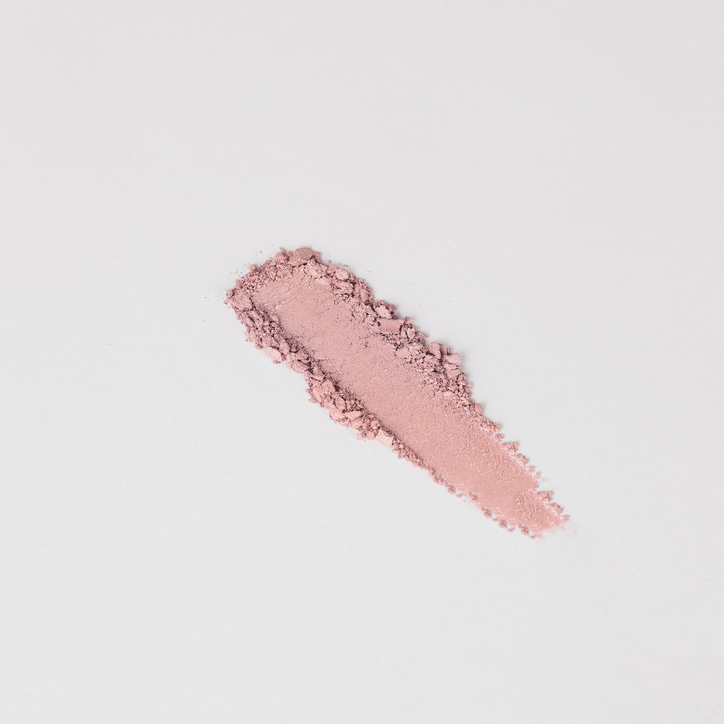 Swatch of Glow Pressed Eyeshadow in pink hue on white background, showcasing smooth texture and rich pigment.