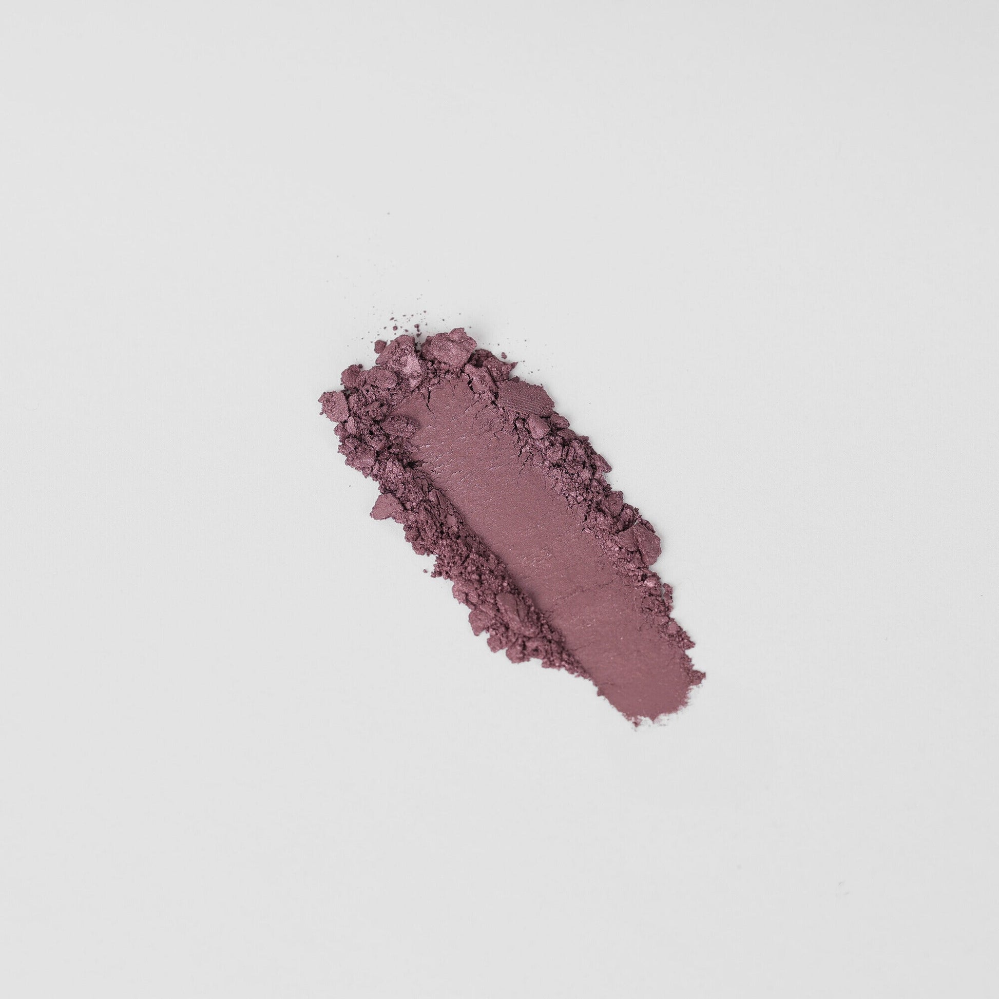 Glow Pressed Eyeshadow swatch in rich purple shade with a smooth finish, showcasing vegan pigments and buildable formula.