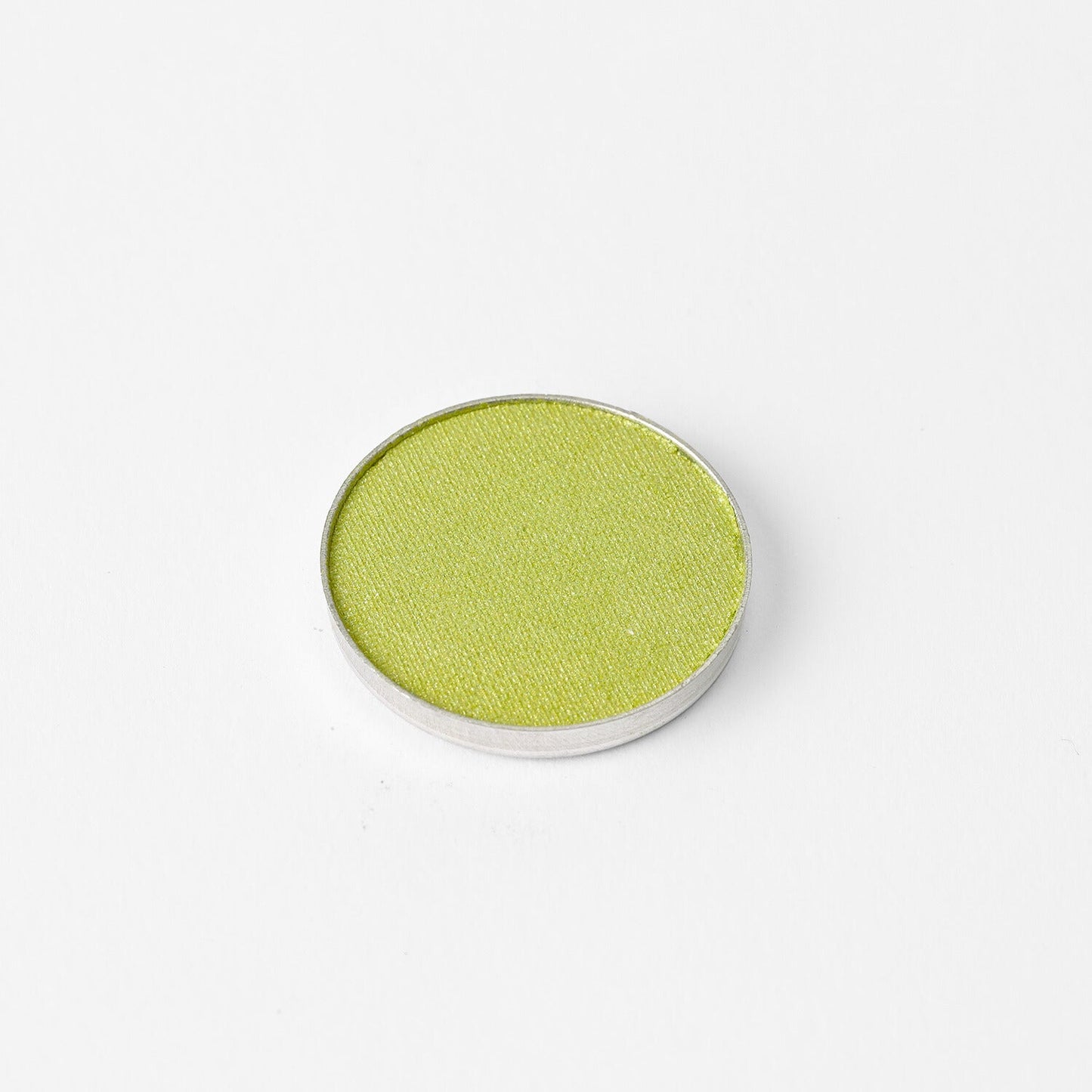 Glow Pressed Eyeshadow in a luminous green pan, providing rich vegan pigments for a smooth, blendable, and long-lasting finish.