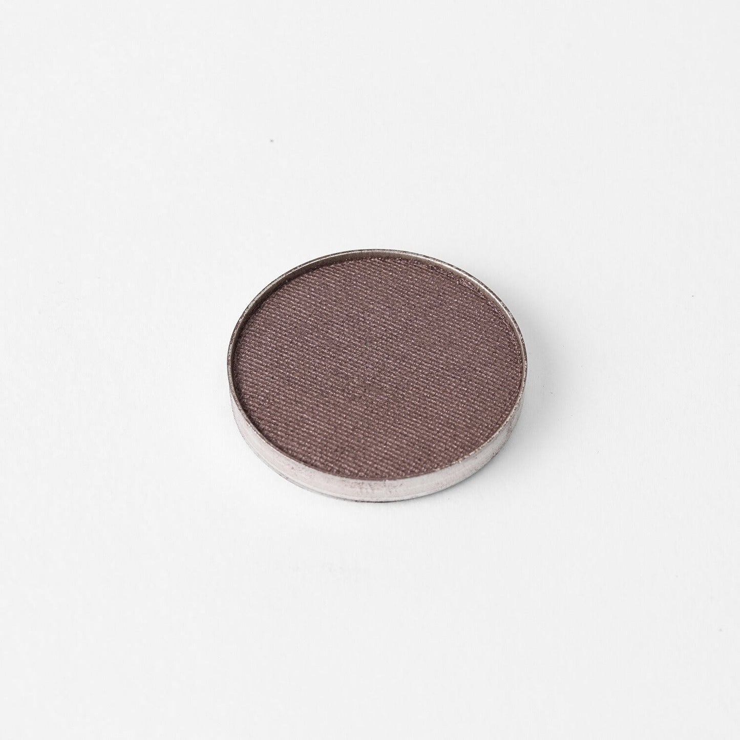 Glow Pressed Eyeshadow in a circular pan showcasing a rich vegan pigment with a smooth, blendable texture.