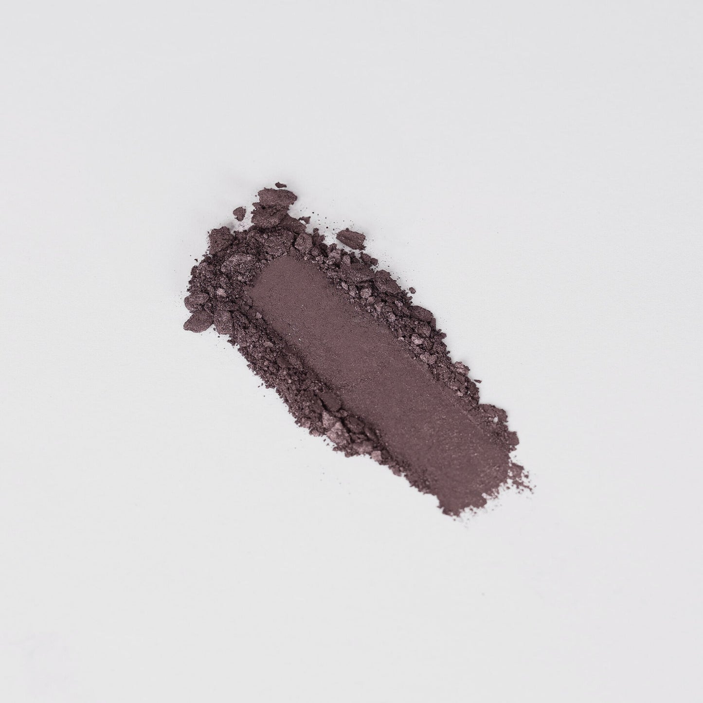 Glow Pressed Eyeshadow in deep purple shade, showcasing its rich vegan pigment and smooth texture on a white background.