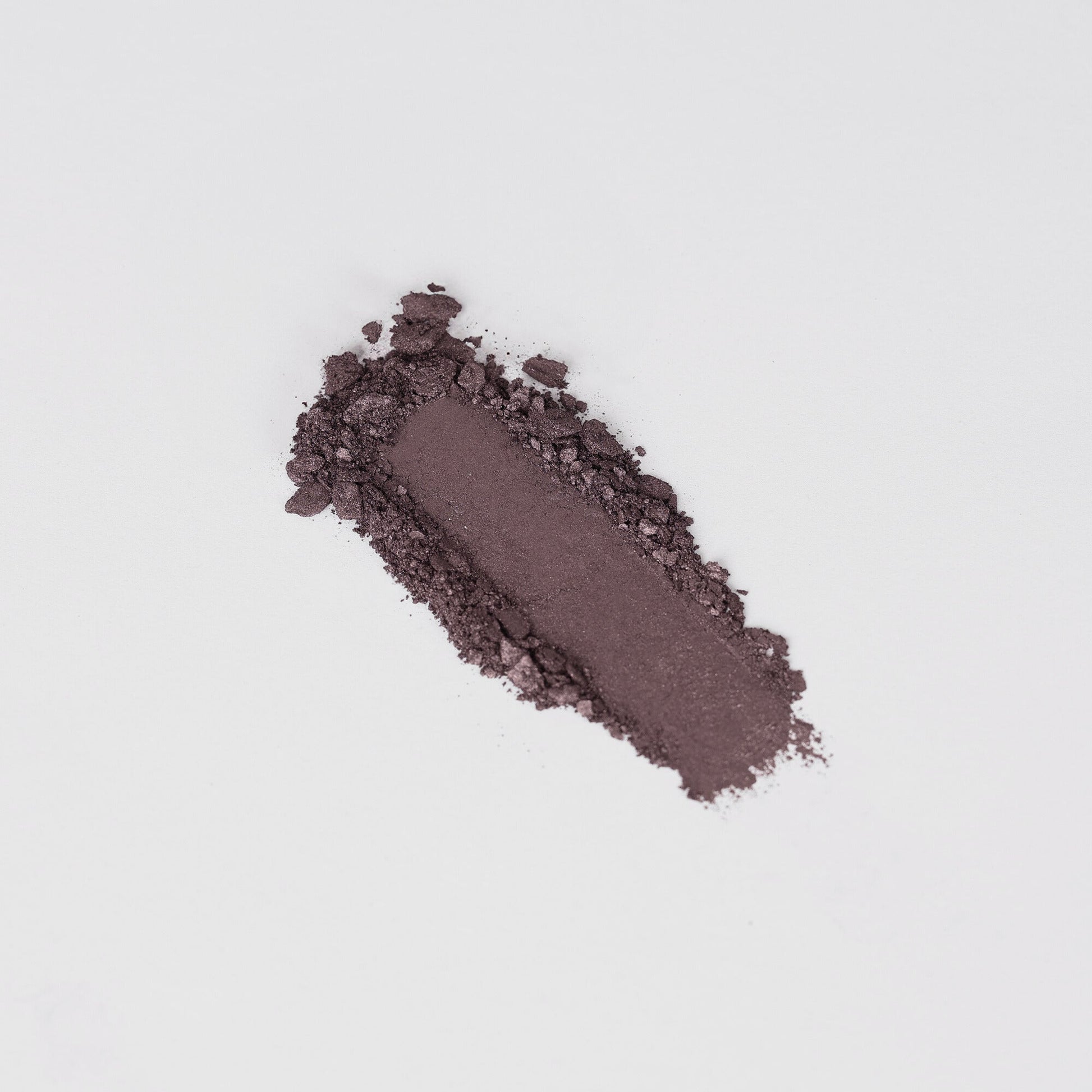 Glow Pressed Eyeshadow in deep purple shade, showcasing its rich vegan pigment and smooth texture on a white background.