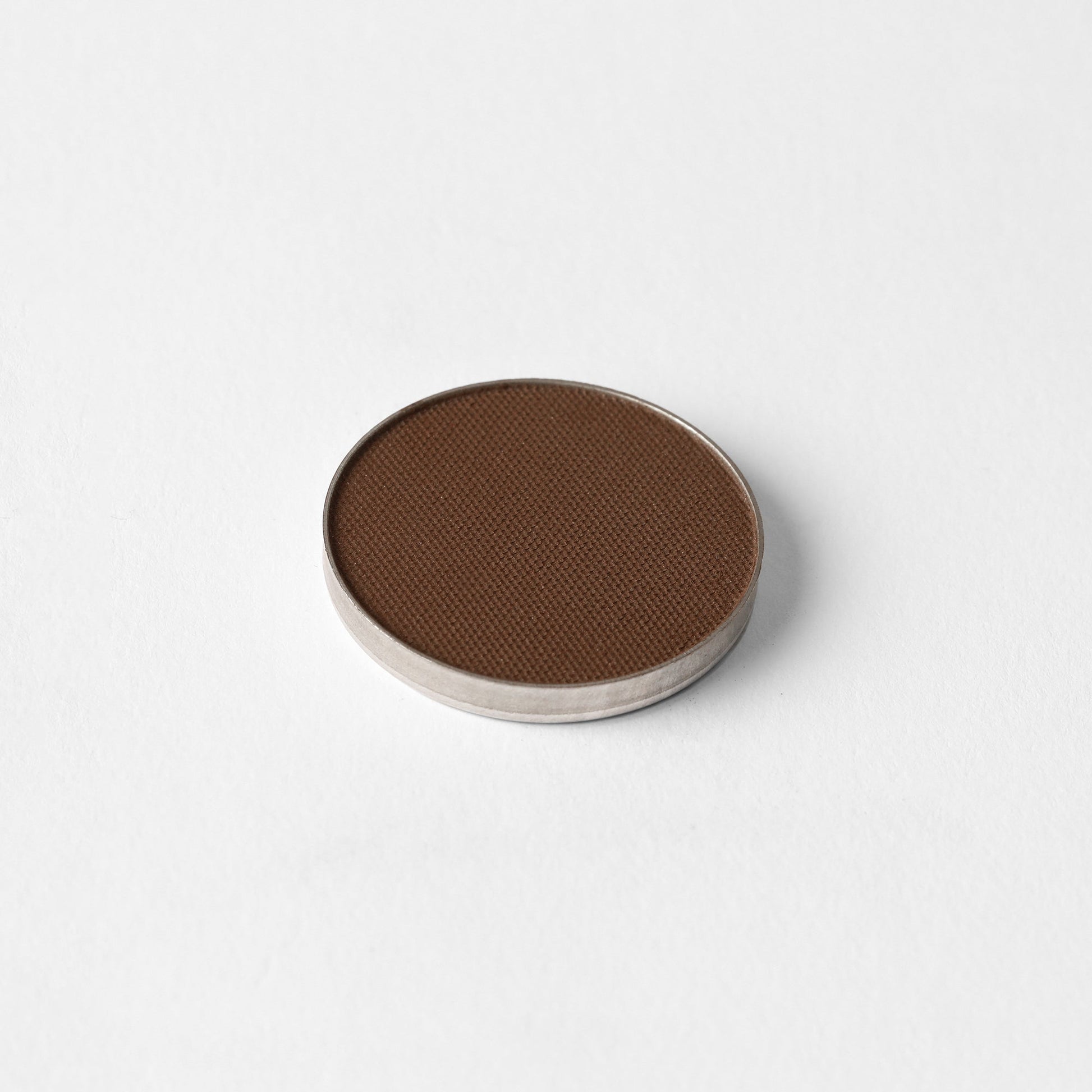 Matte Pressed Eyeshadow in a single pan, rich brown color with smooth, blendable vegan pigments for versatile makeup application.