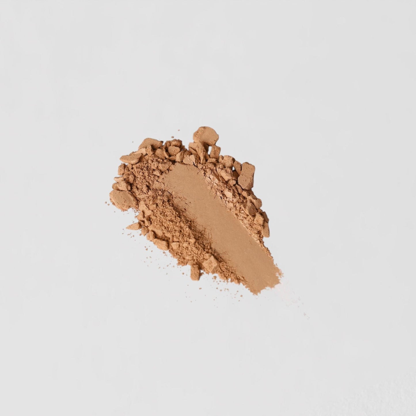 Close-up of vegan Face Powder swatch on white background, showcasing its lightweight formula and seamless layering.