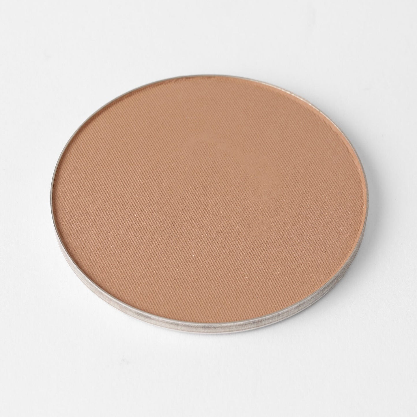 Round vegan Face Powder in a magnetic pan for seamless application, offering lightweight and long-lasting coverage.