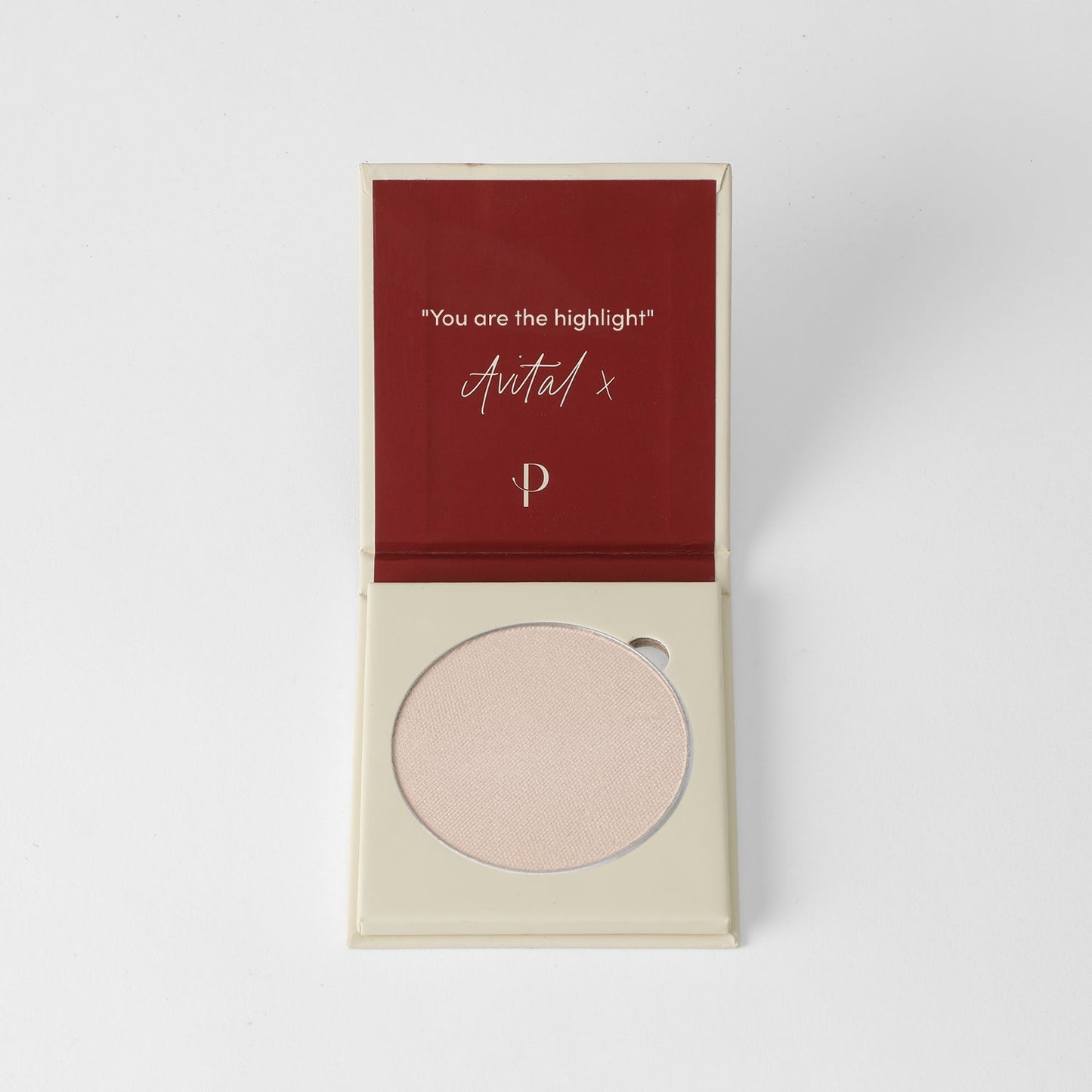 Highlighter in open compact case with text "You are the highlight" on lid