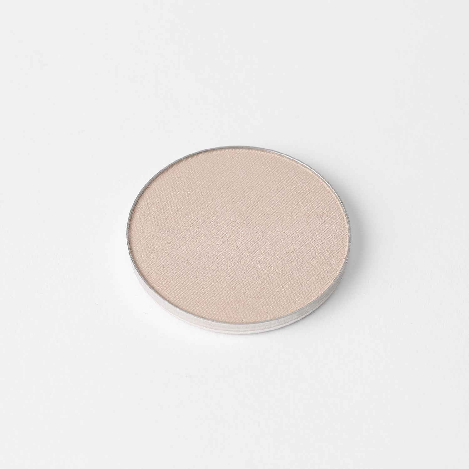 Highlighter in round silver pan for magnetic palettes, smooth finish, vegan and buildable, shown on white background.
