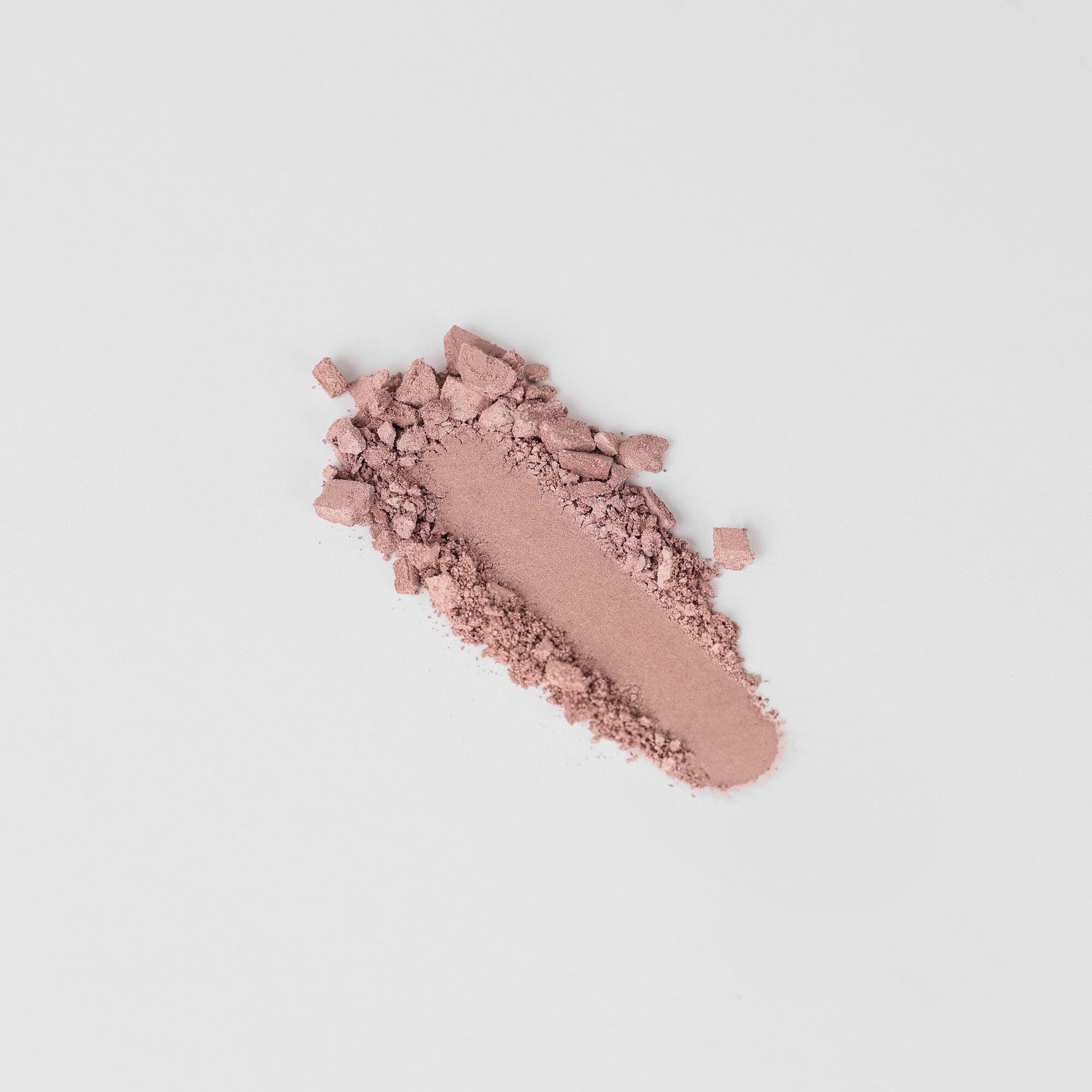 Highlighter in a crushed powder form showcasing its soft pink shade; perfect for creating a radiant, dimensional shine.