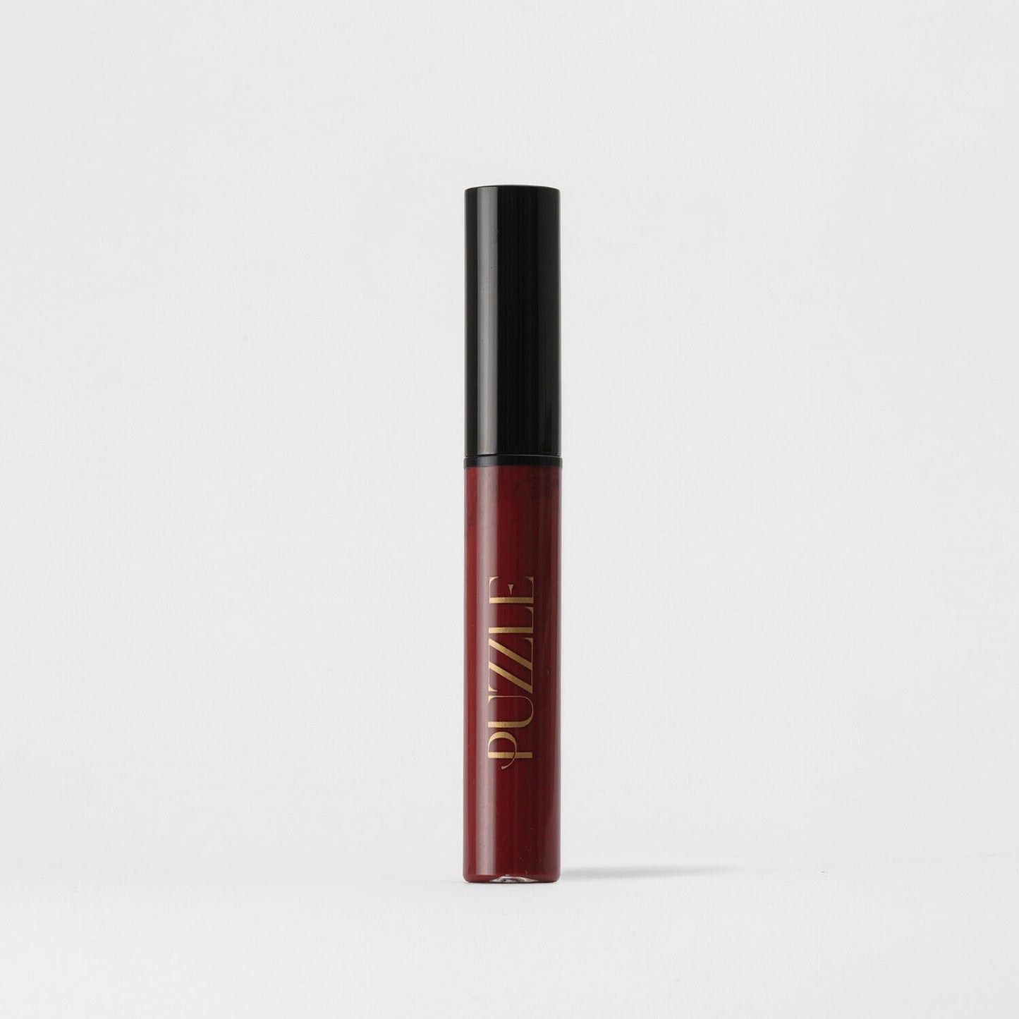 Puzzle branded Lip Gloss Wand in a sleek tube, offering non-sticky, vegan gloss for nourished lips with a high-shine finish.