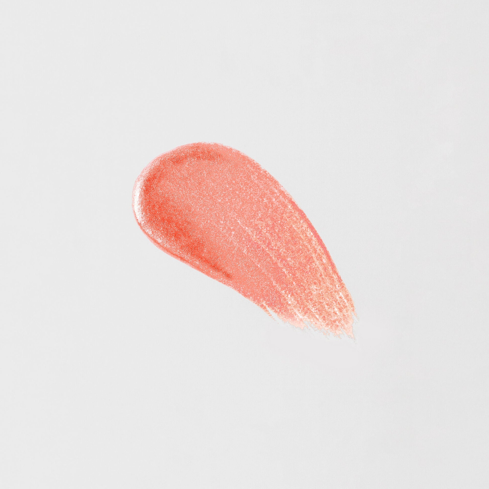 Lip Gloss Wand swatch showing high-shine peach shade with smooth, vegan formula for a dimensional glow and nourished lips.
