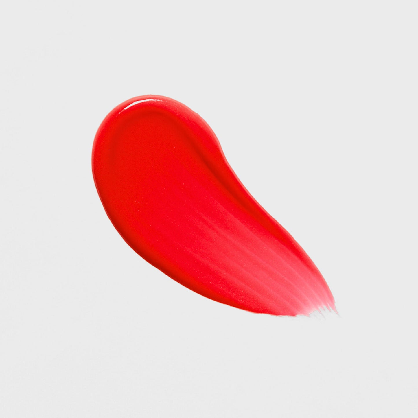 Bright red swatch of Lip Gloss Wand showcasing high-shine, vegan formula for a dimensional glow and smooth, nourished lips.