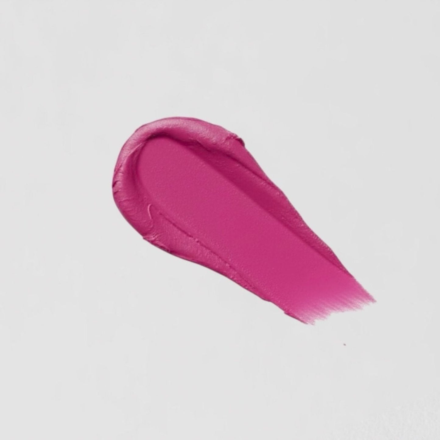 Swatch of vibrant pink vegan Lip Stain showcasing velvety-matte texture and long-lasting wear.