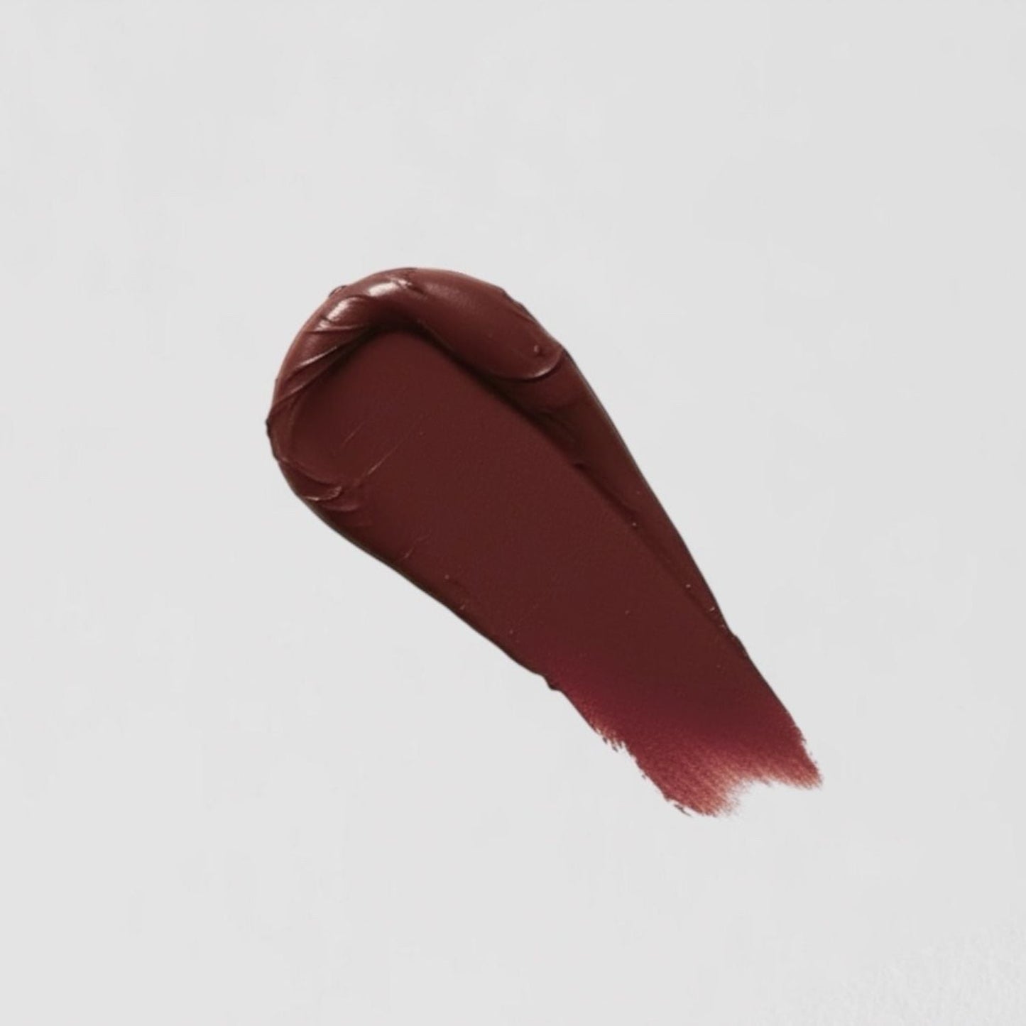 Swatch of vegan Lip Stain in a deep burgundy shade on a white background, showcasing matte finish and nourishing formula.