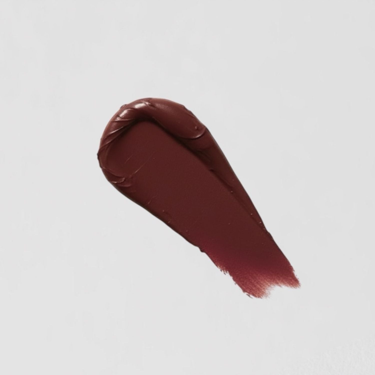 Swatch of vegan Lip Stain in a deep burgundy shade on a white background, showcasing matte finish and nourishing formula.