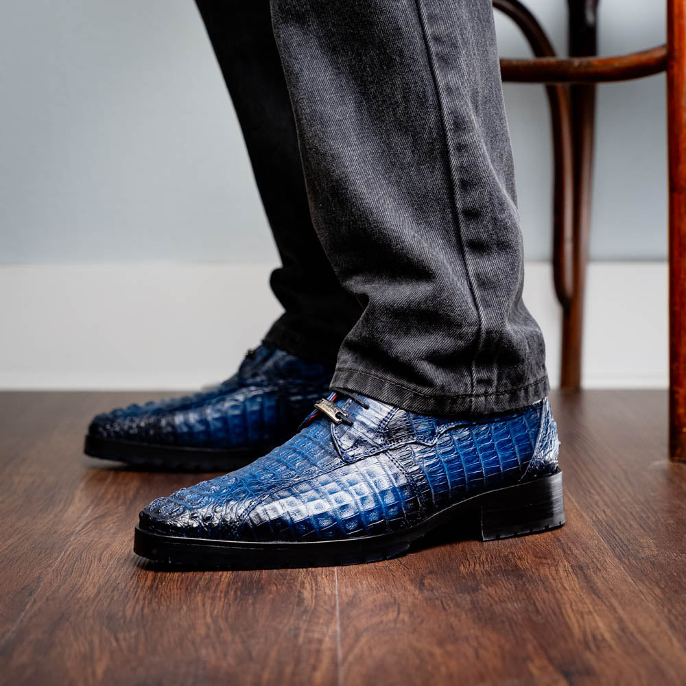 Ragusa Stained Navy genuine caiman skin derby shoe with hybrid sole worn by a person standing on wooden floor.