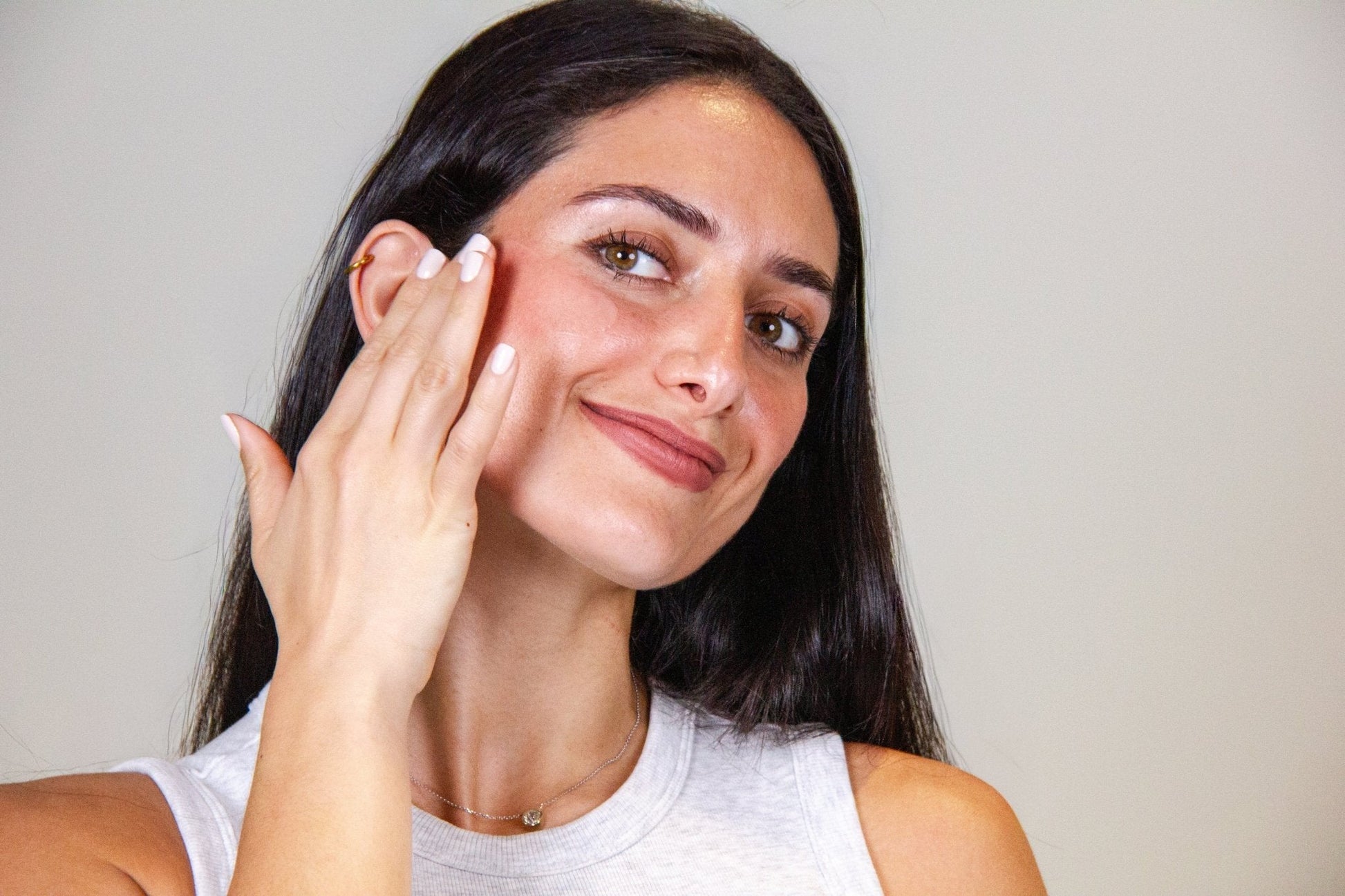Woman applying Retinol Wrinkle Defense Serum to her face for smoother skin and reduced fine lines.