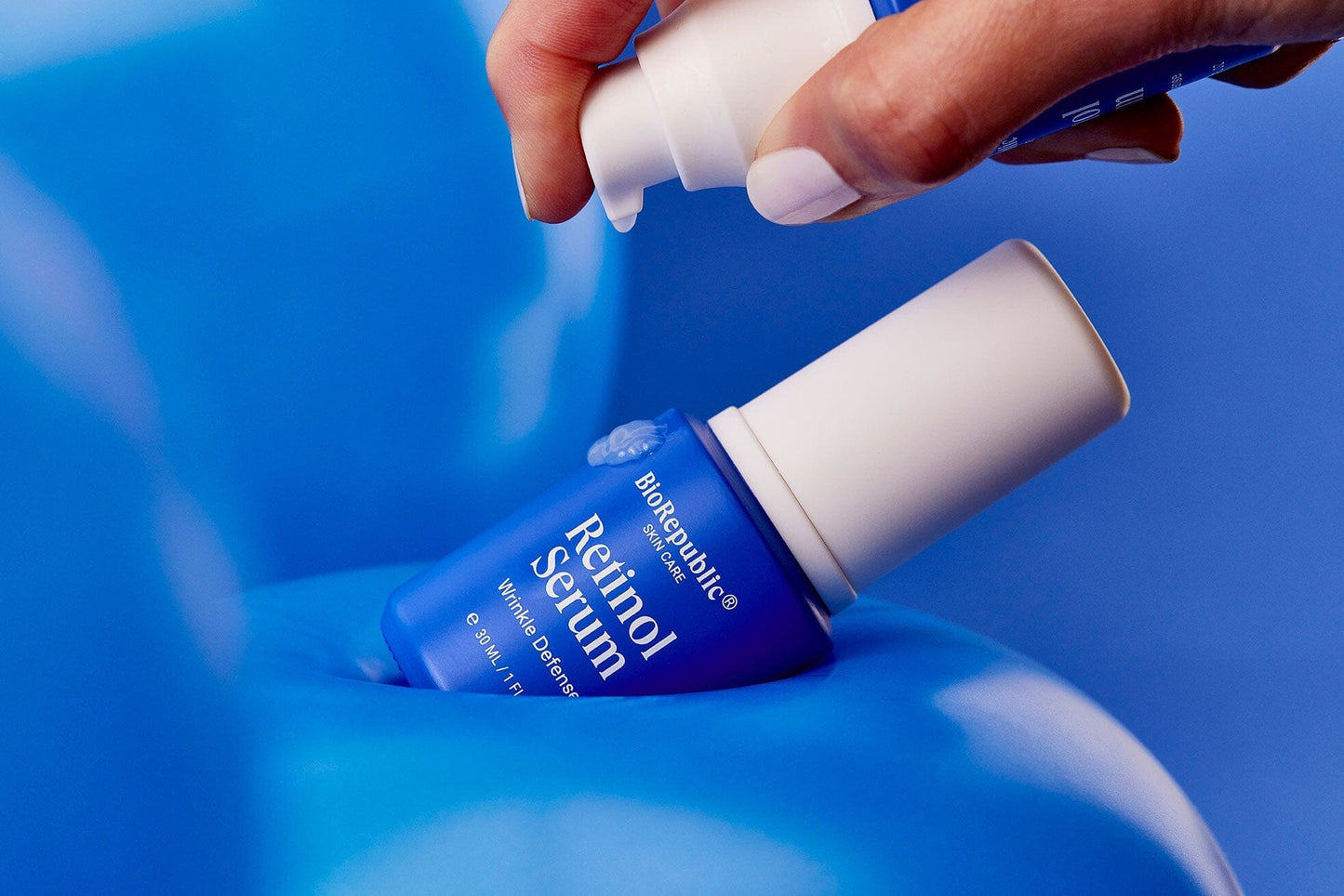 Applying Retinol Wrinkle Defense Serum for smoothing fine lines and wrinkles, featuring a premium 2.6% retinol complex.