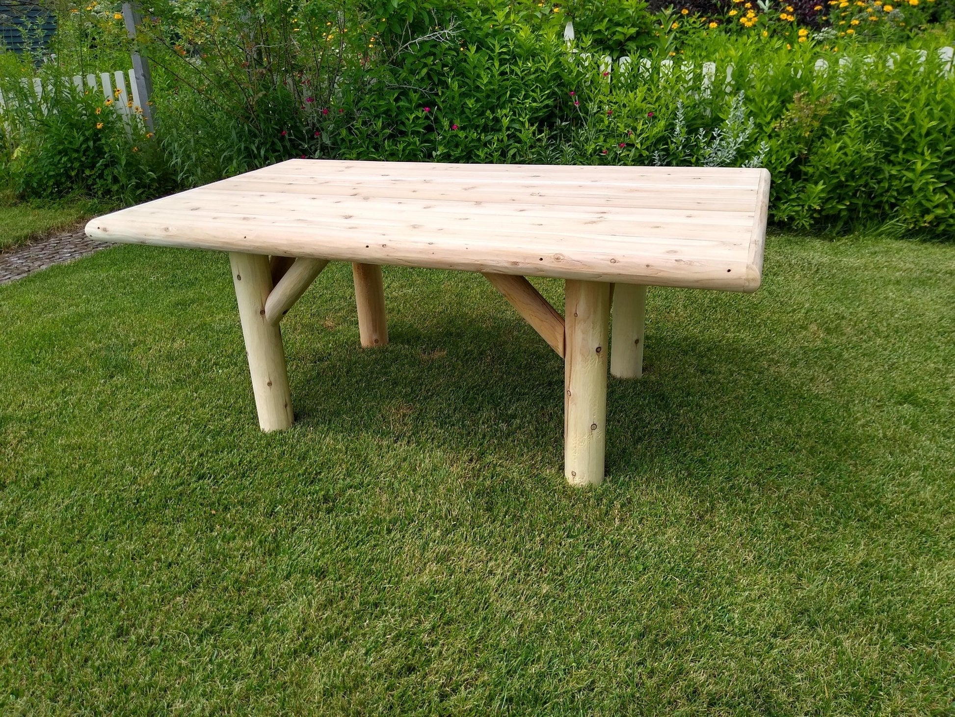 Rustic Outdoor Wooden Patio Table on green grass, showcasing handcrafted cedar design and weather-resistant durability.