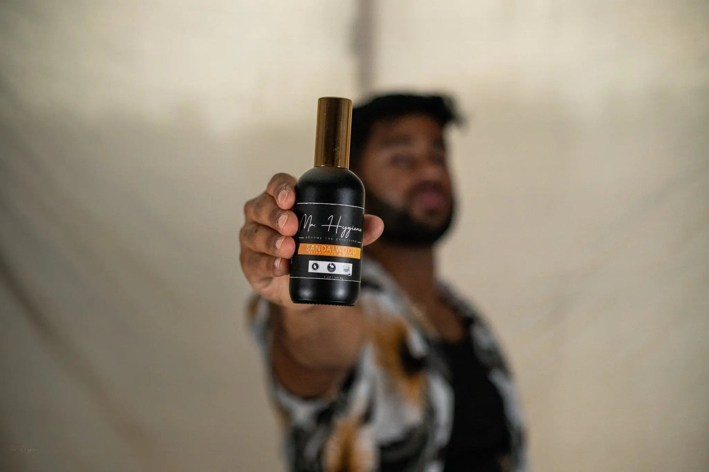 Man holding Sandalwood Aftershave & Toner bottle, highlighting skin nourishment and soothing benefits for men.