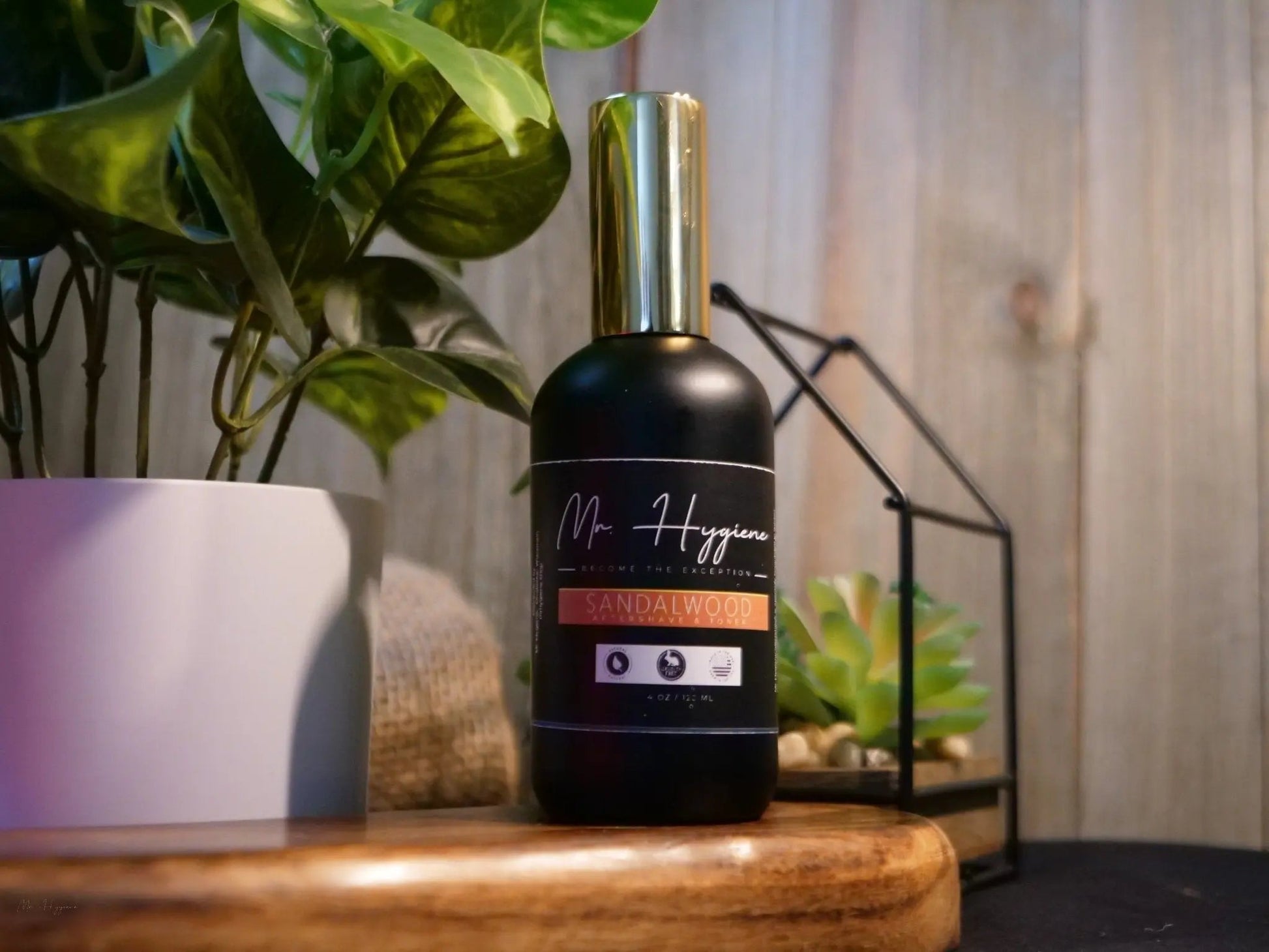 Bottle of Sandalwood Aftershave & Toner on a wooden shelf with plants