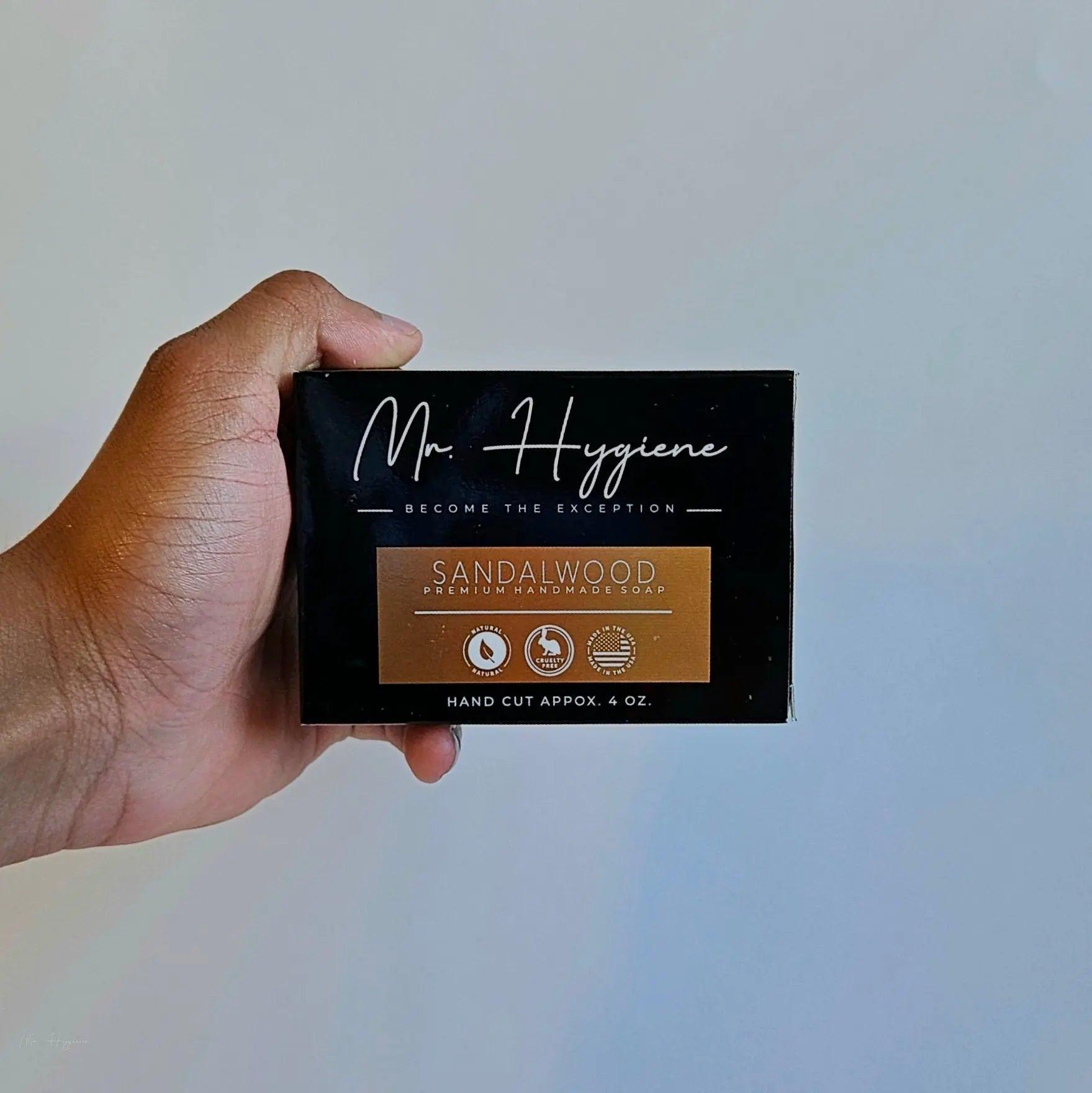 Close-up of Sandalwood Bar Soap – Classic Scent, Deep Clean in black packaging held in hand, highlighting natural and eco-friendly features.