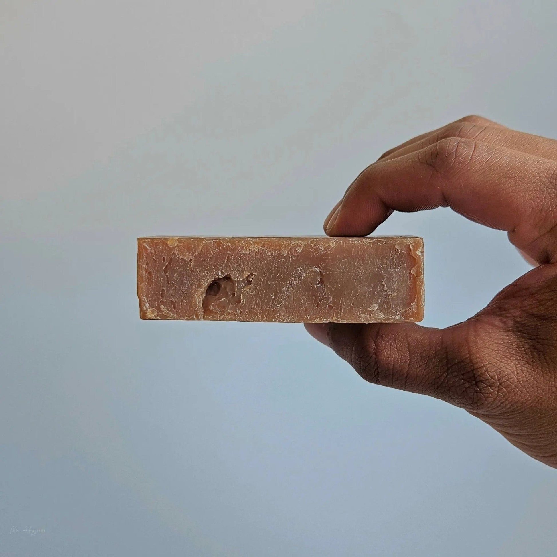 Hand holding Sandalwood Bar Soap – Classic Scent, Deep Clean for effective natural skincare and rejuvenation.