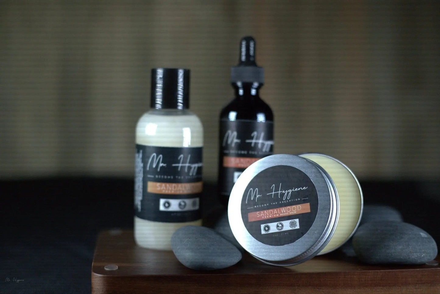 Sandalwood Beard Kit – Bold Scent, Complete Care featuring beard oil, balm, and wash by Mr. Hygiene on display with smooth stones.