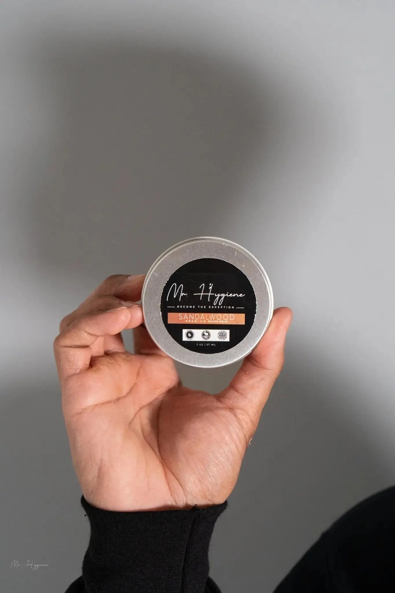 Hand holding Sandalwood Beard Balm for Men – Shape, Soften & Scent container for beard grooming.