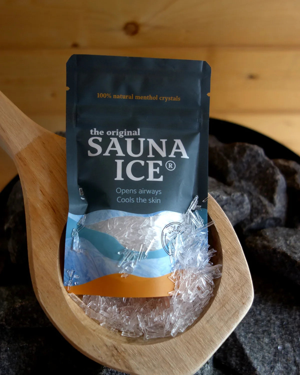 Package of Sauna Ice menthol crystals on a wooden ladle, perfect for enhancing your sauna experience by cooling and opening airways.