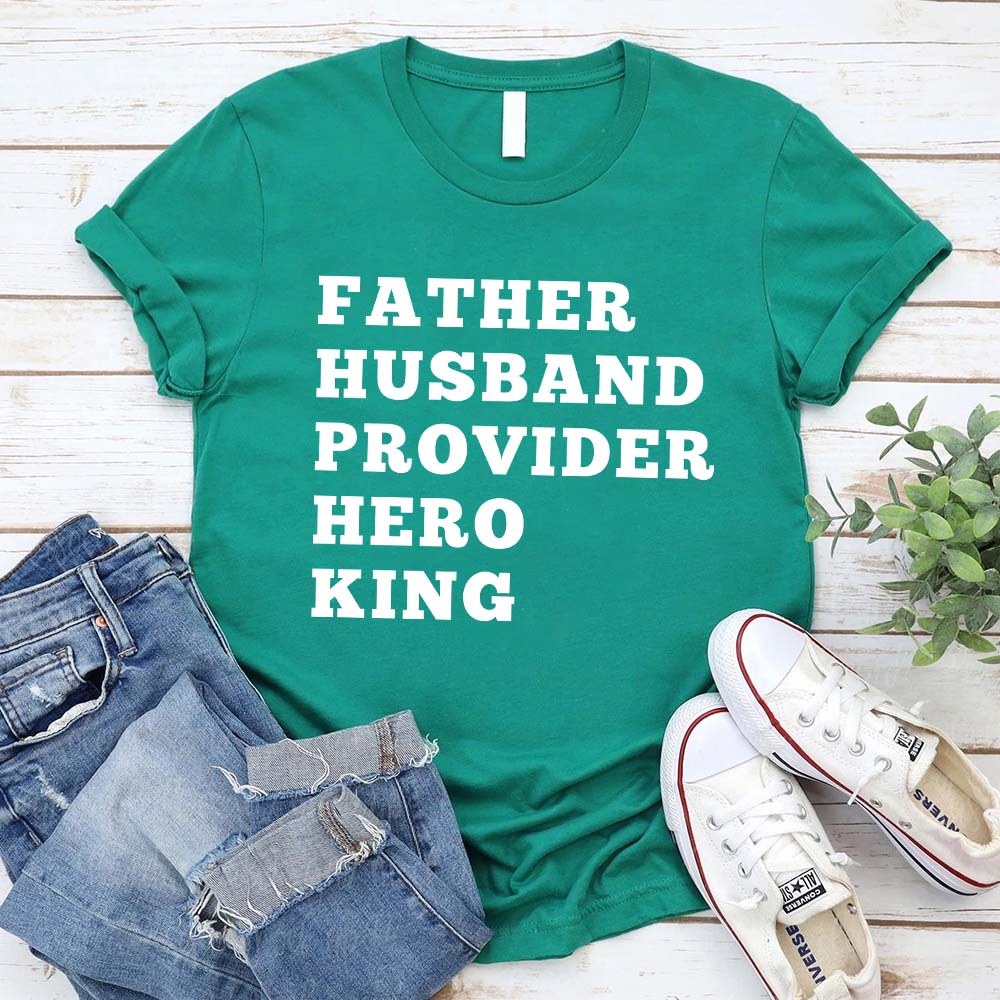 Father Husband Provider Hero King T-shirt in green with white text, displayed with jeans and sneakers, honoring fatherhood.