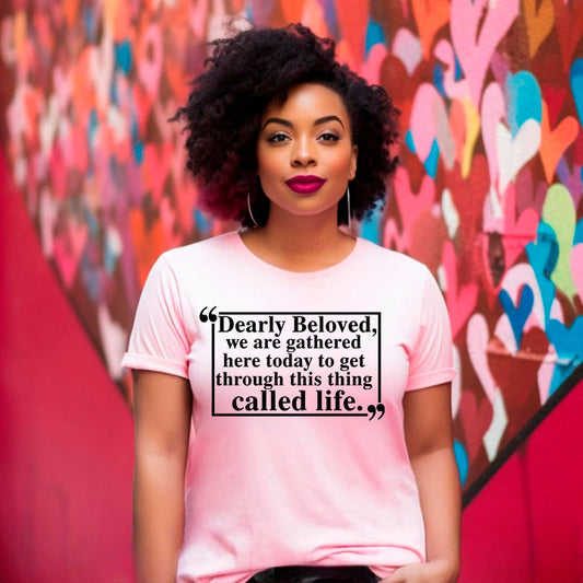 Woman wearing the Dearly Beloved Tee Unisex Funny Quote Shirt in front of heart mural