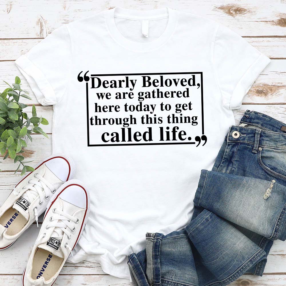 Dearly Beloved Tee Unisex Funny Quote Shirt laid flat with jeans and sneakers.