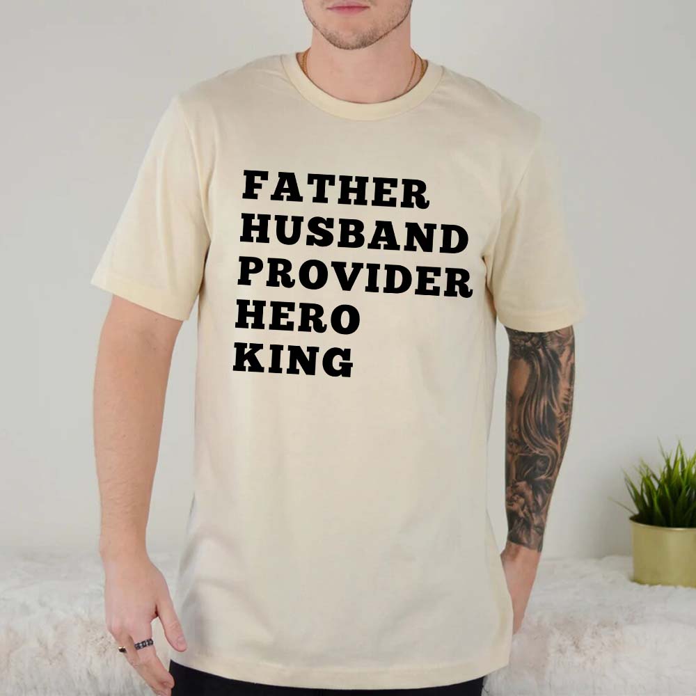 Father Husband Provider Hero King T-shirt in cream color worn by a model, showcasing bold lettering for fathers with honor and pride.