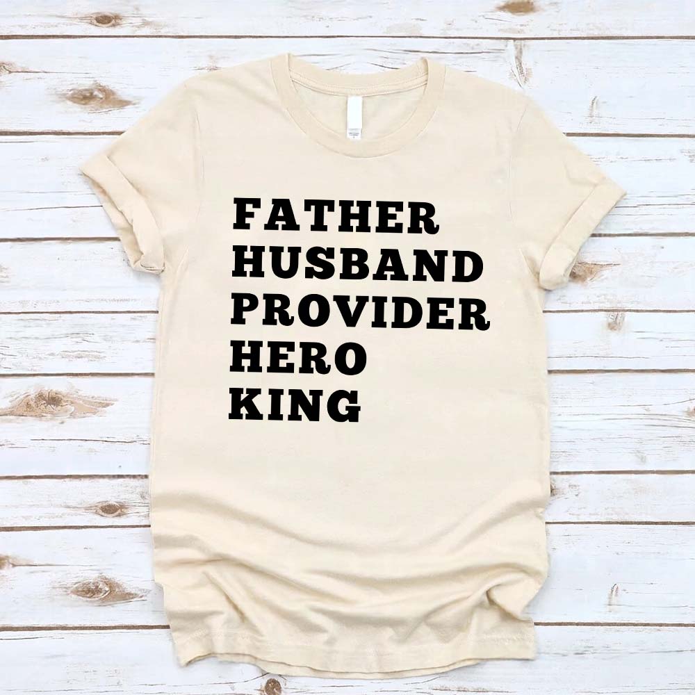Father Husband Provider Hero King T-shirt on wooden surface, cotton, beige color.