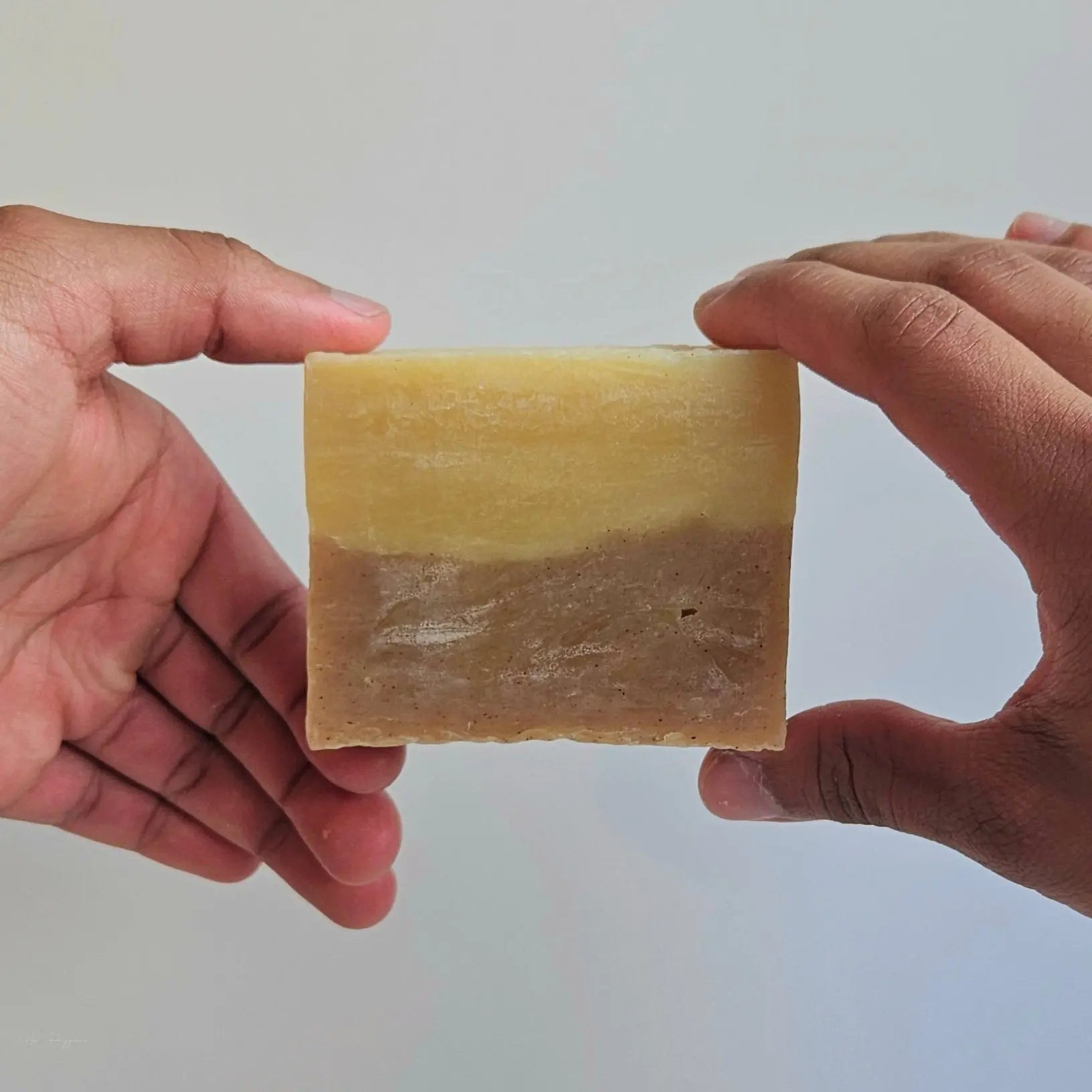 Hands holding Sweet Spice Cleanser Luxury Mens Soap bar with warm spice aroma and eco-friendly cleansing properties.