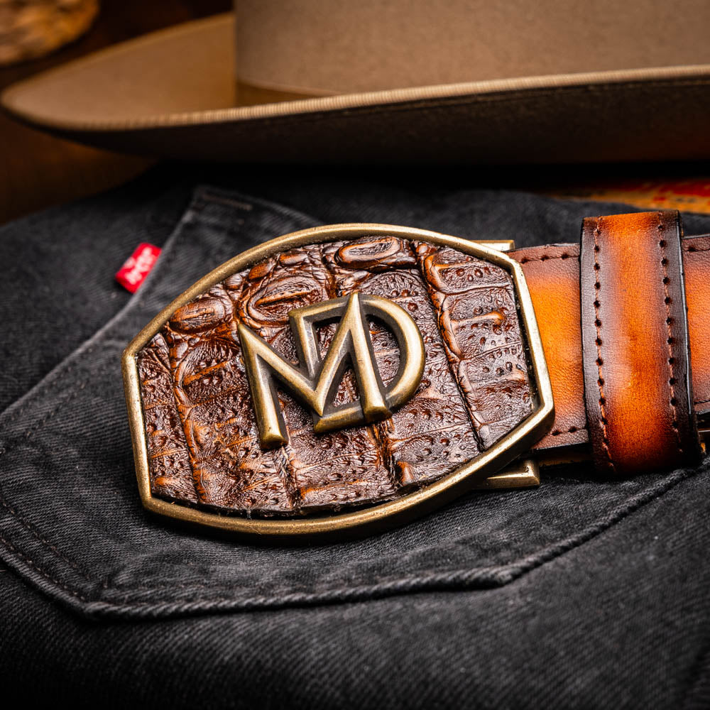 Texas Belt Aged Brown with caiman and calfskin featuring Marco Di Milano insignia on dark clothing backdrop.