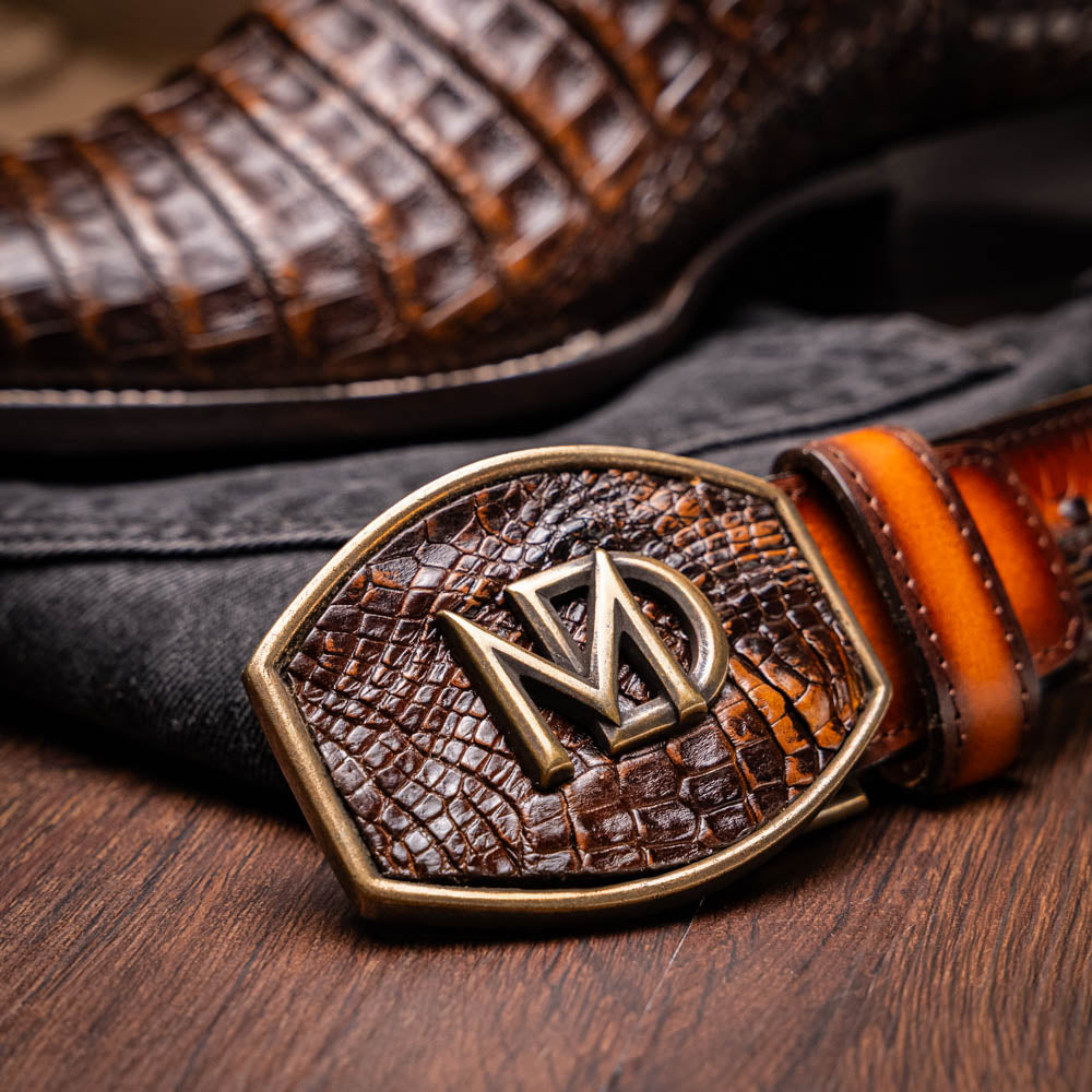 Tucson Aged Brown cowboy boot crafted from genuine caiman belly skin with a bold square-toe profile, displayed with a matching leather belt.