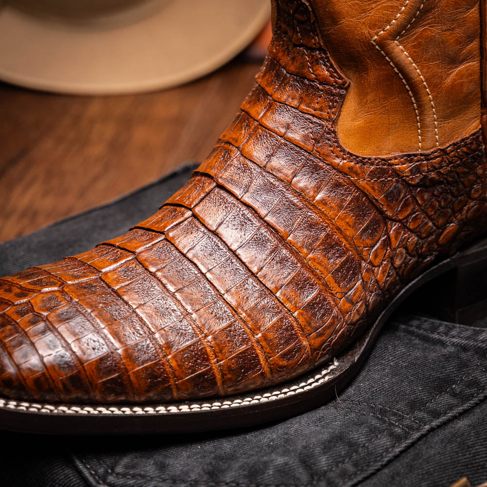 Close-up of Tucson Aged Maple cowboy boot made from genuine caiman belly skin, featuring bold texture and square-toe design.