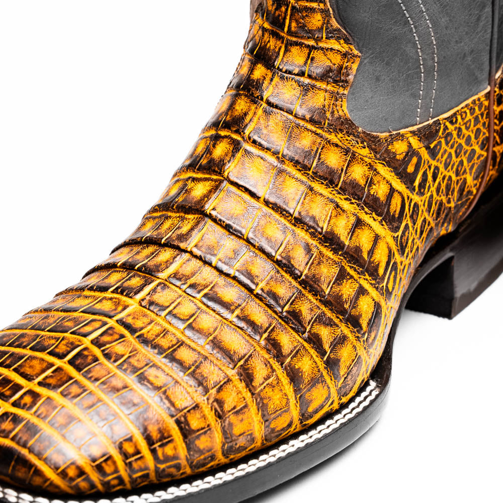 Close-up of Tucson Mustard Brown cowboy boot made from genuine caiman belly skin with square-toe profile, showcasing detailed craftsmanship.