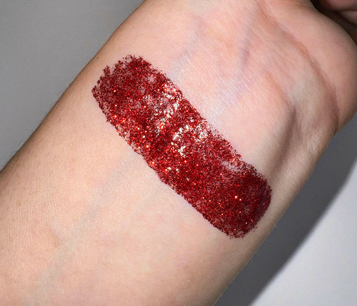 Swatch of Vampy - Flicker Glitter Eyeliner in deep red sparkly shade on skin