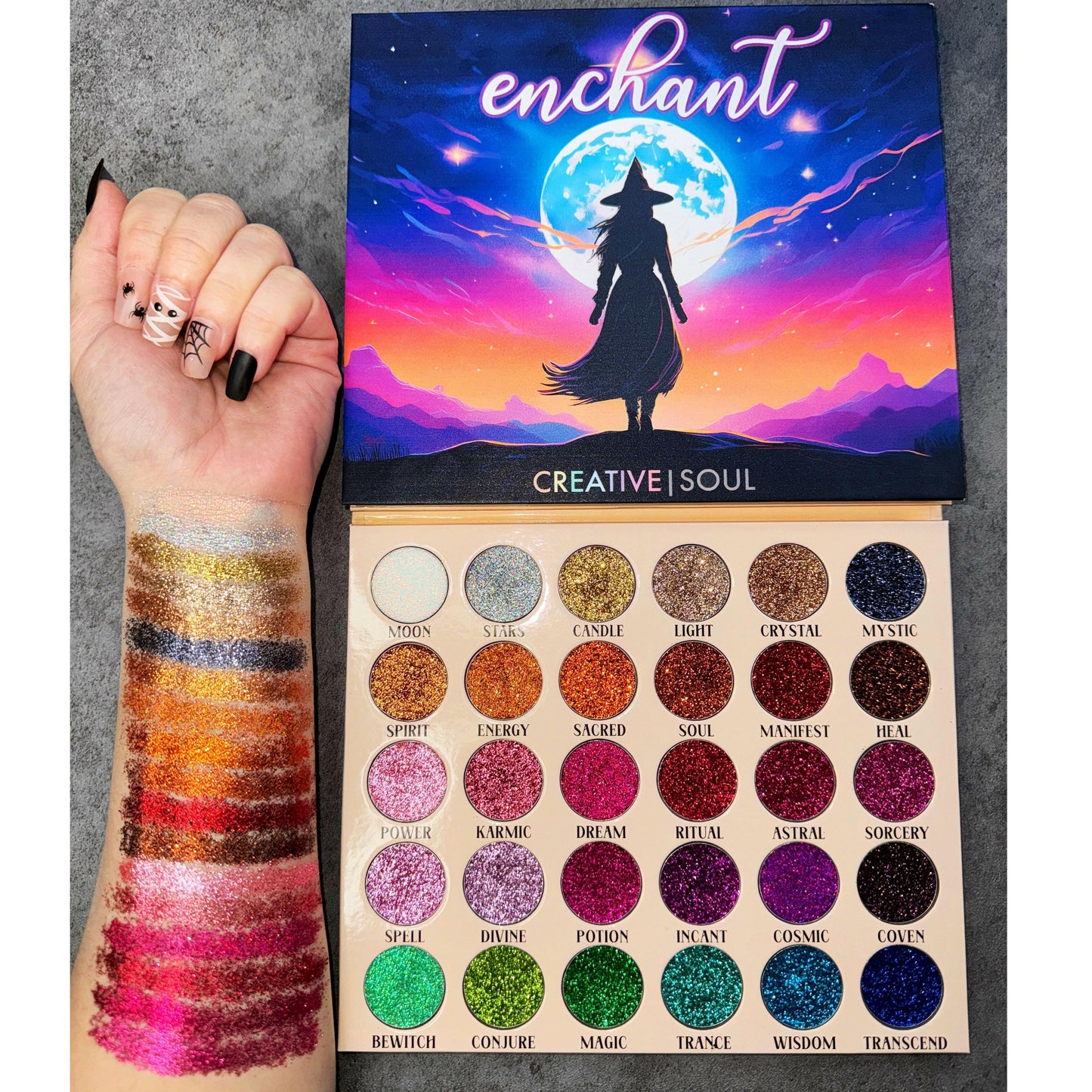 Enchant Pressed Glitter Eyeshadow Palette with 30 vibrant glitter shades swatched on arm.