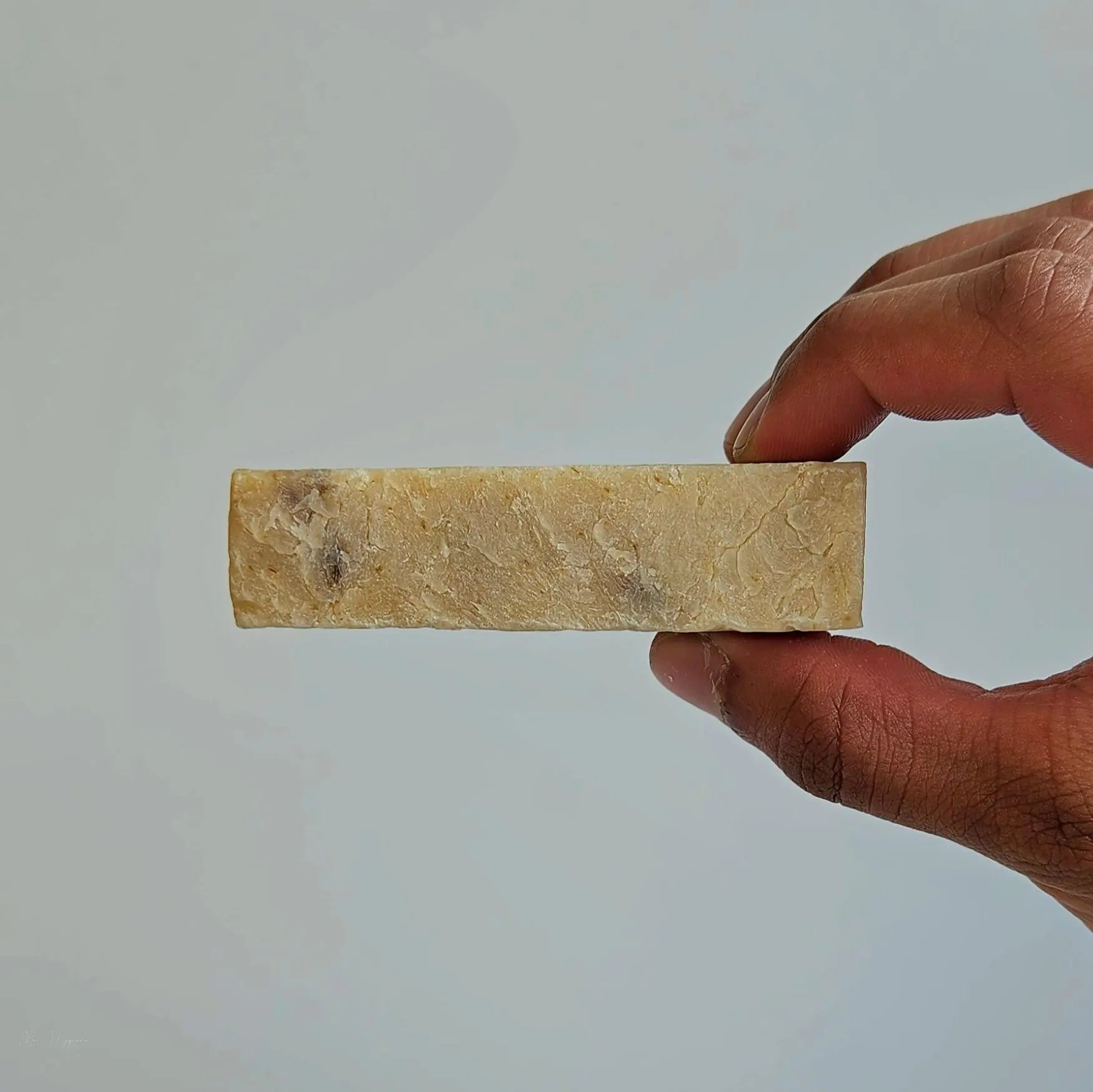 Person holding Wilderness Warrior Bar Soap showcasing its earthy texture and natural ingredients.